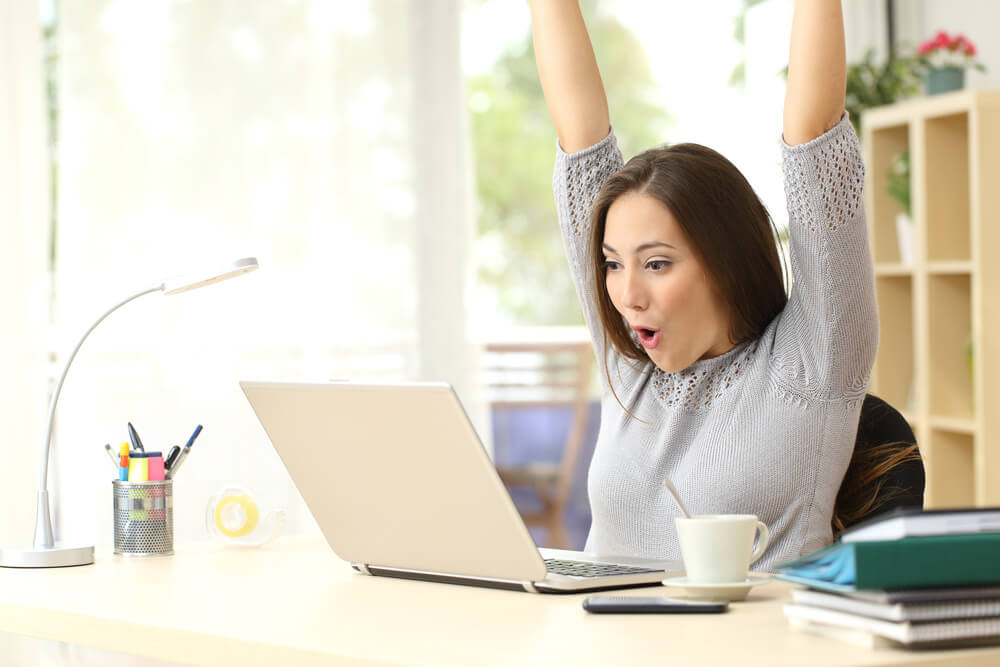 woman celebrating her flex loan on computer