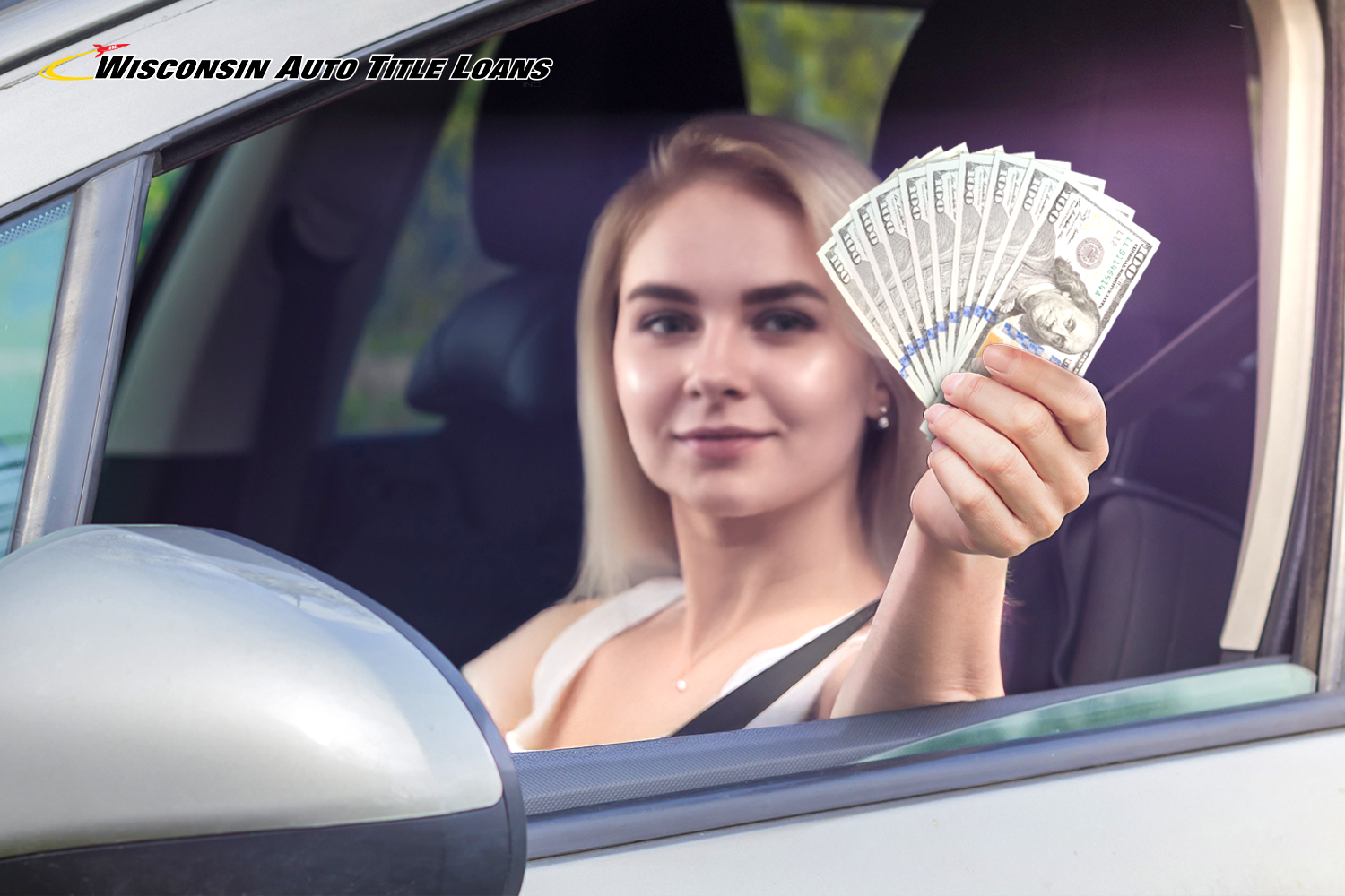 woman holds title loan cash while driving her car