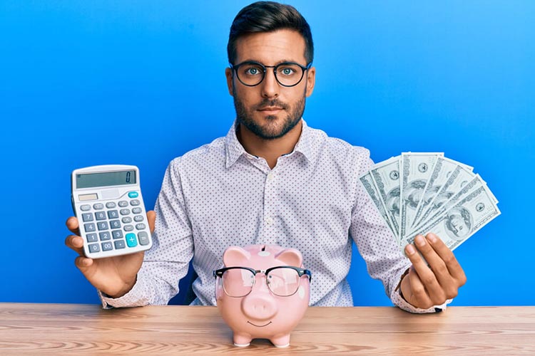 man holds up money and calculator for budgeting strategies