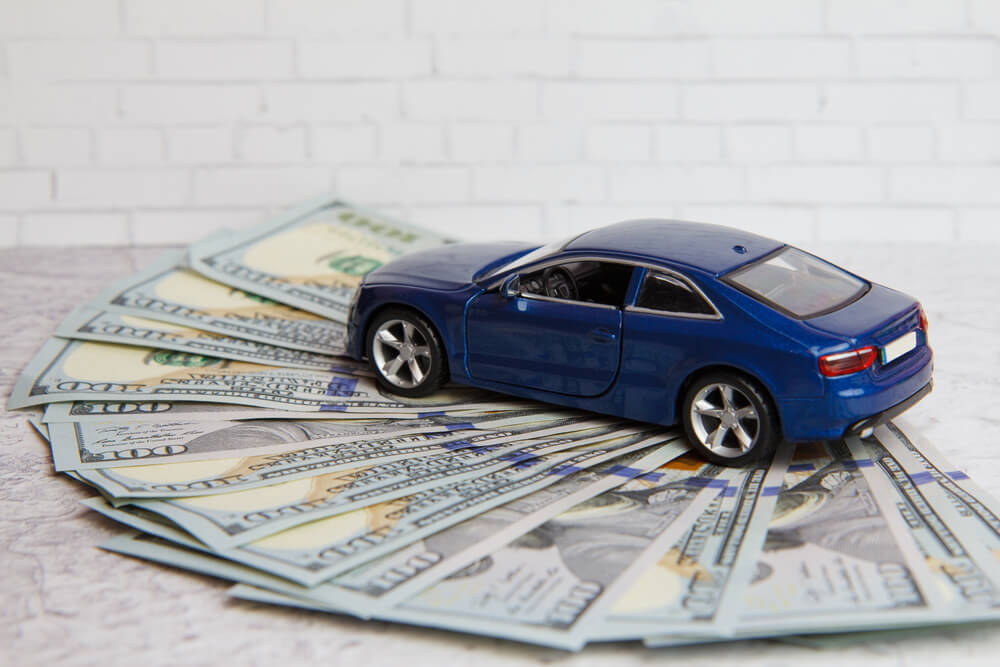 car registration loan cash with blue toy car on top of it