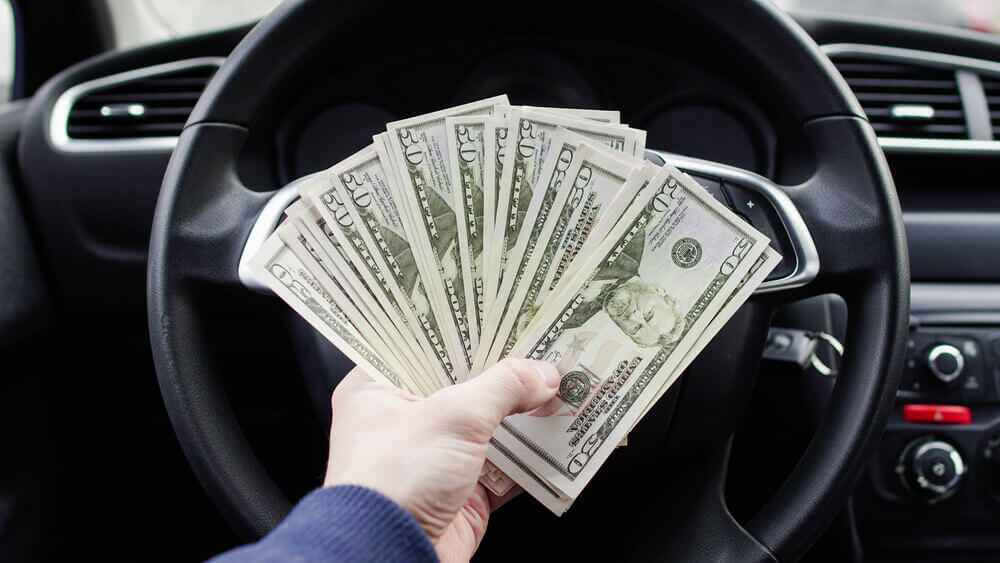 man holding cash from car collateral loan