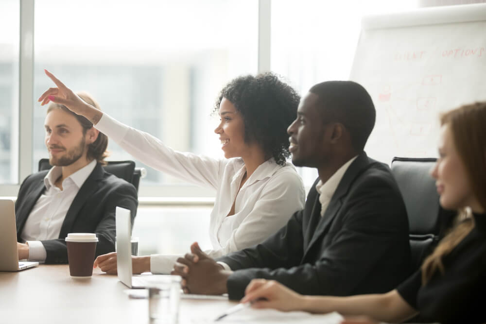 woman asking questions during meeting at new job