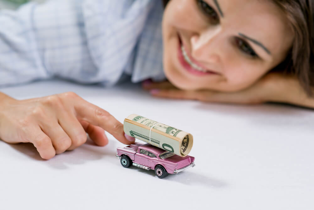 woman playing with toy car with Alabama title pawn cash on it