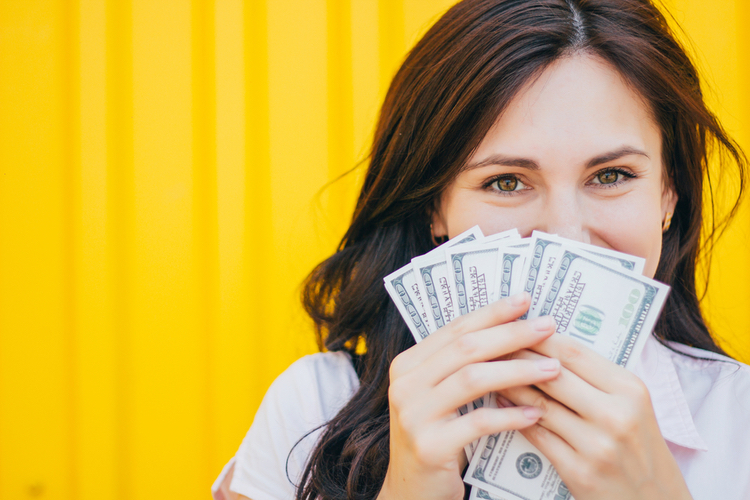 Woman holding hundreds in quick cash from a Utah title loan