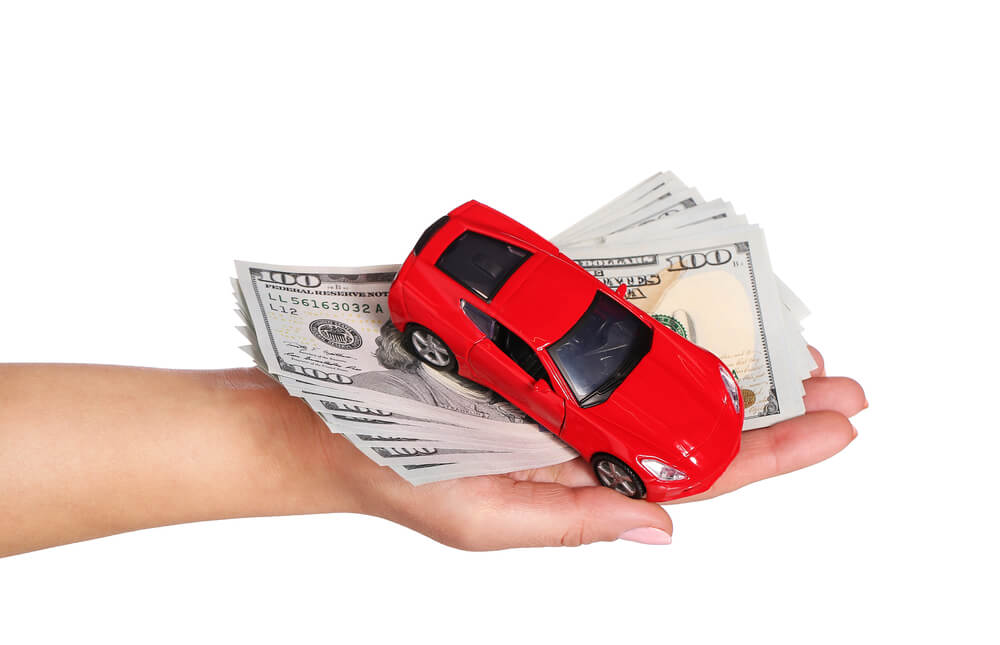 Hand that has red toy car and Arizona title loan cash 