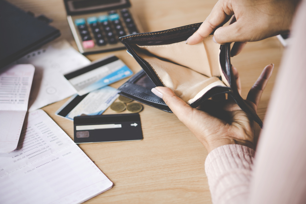 person looking through empty wallet with Title pawn paperwork on desk