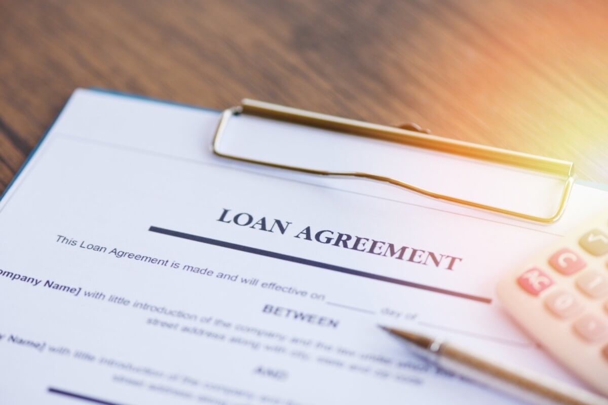 loan agreement for title pawn on clipboard with pen and calculator