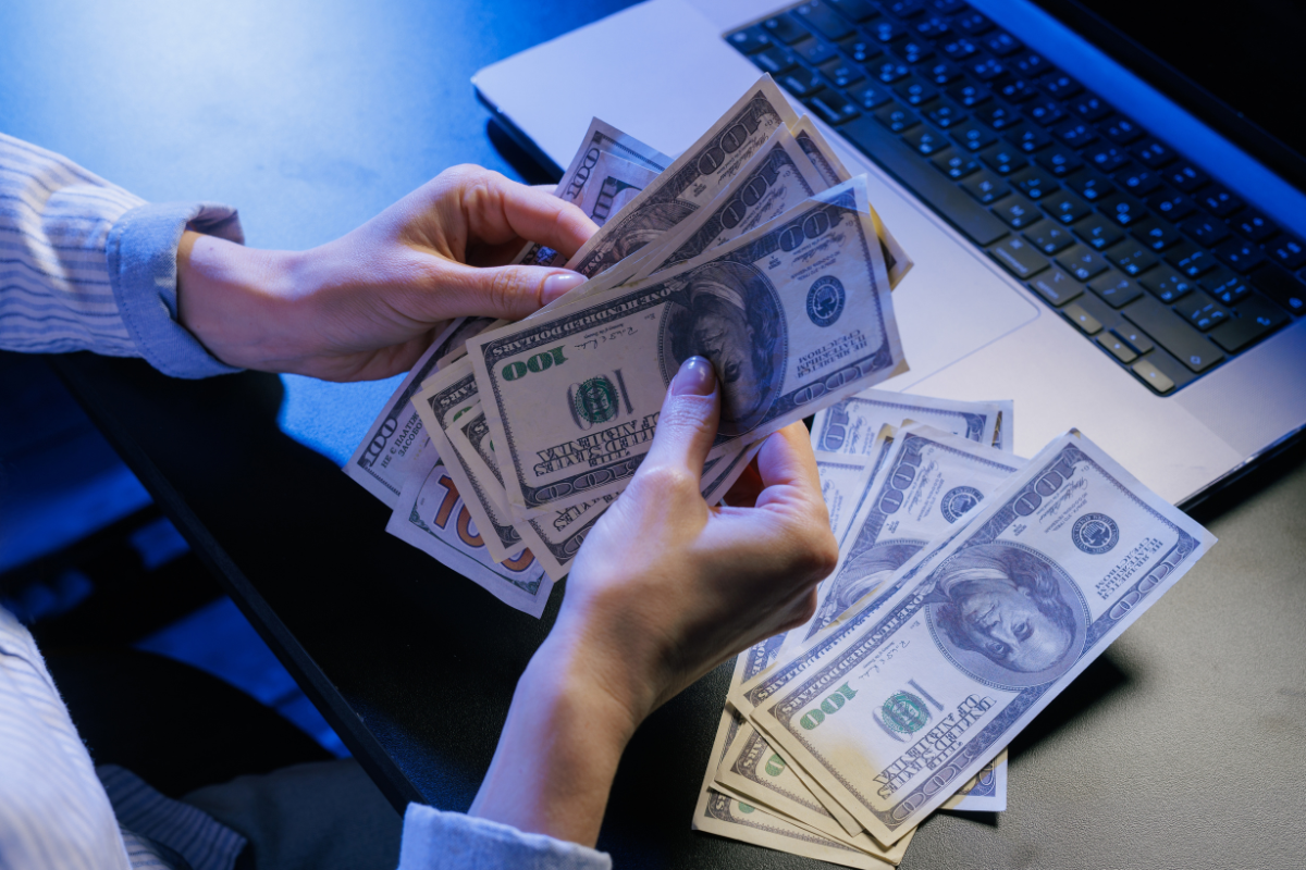 borrower with laptop counting cash