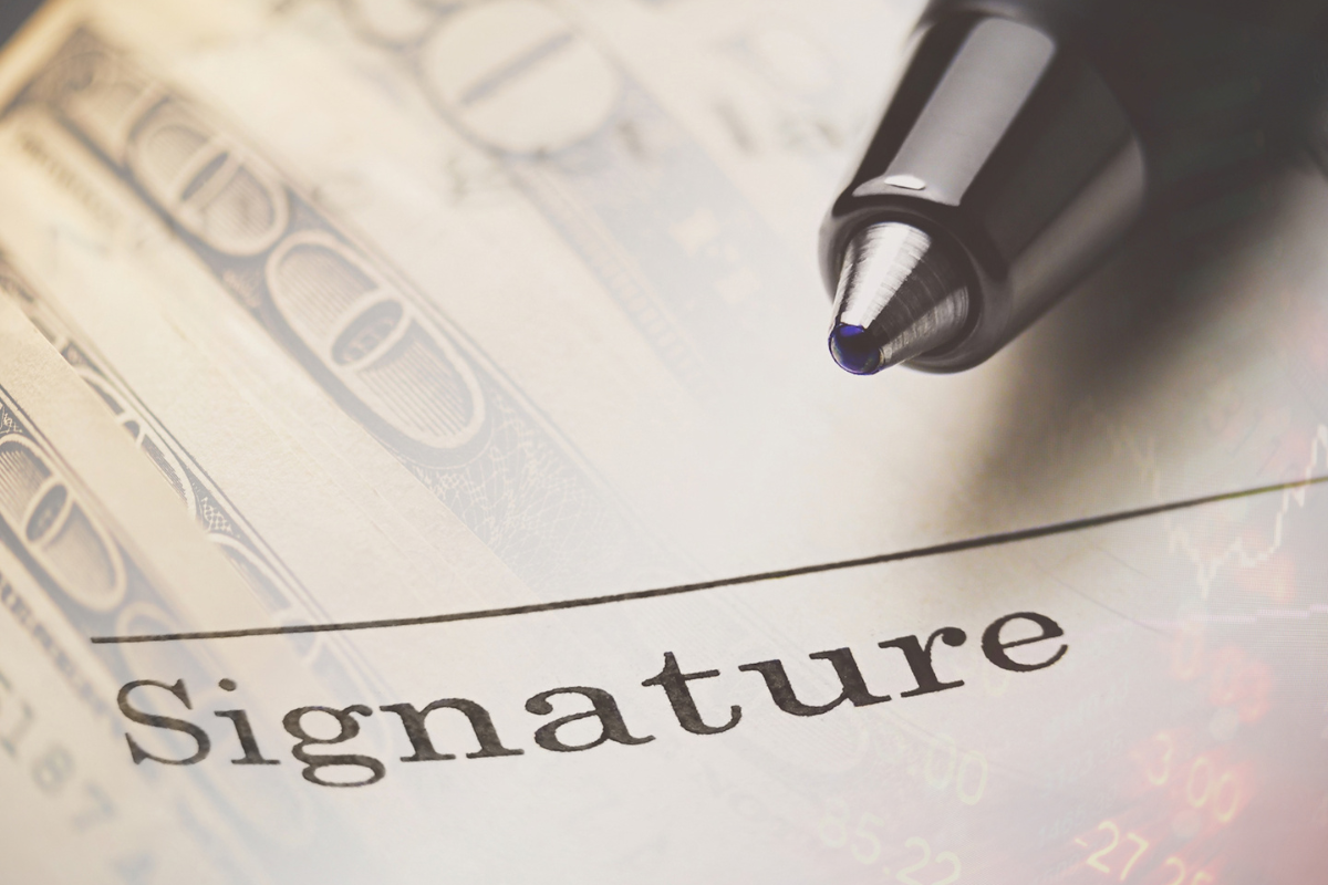 money with signature line and pen