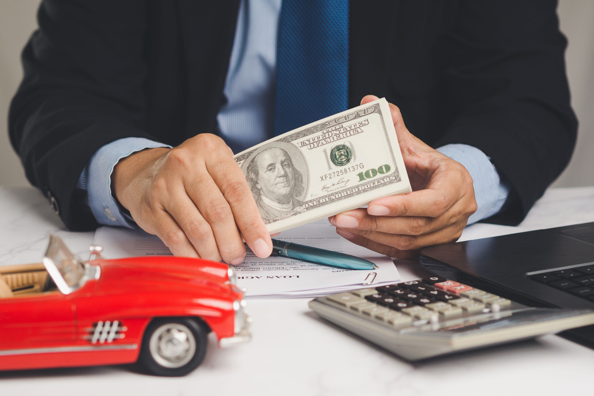 man with calculator providing car title loan cash