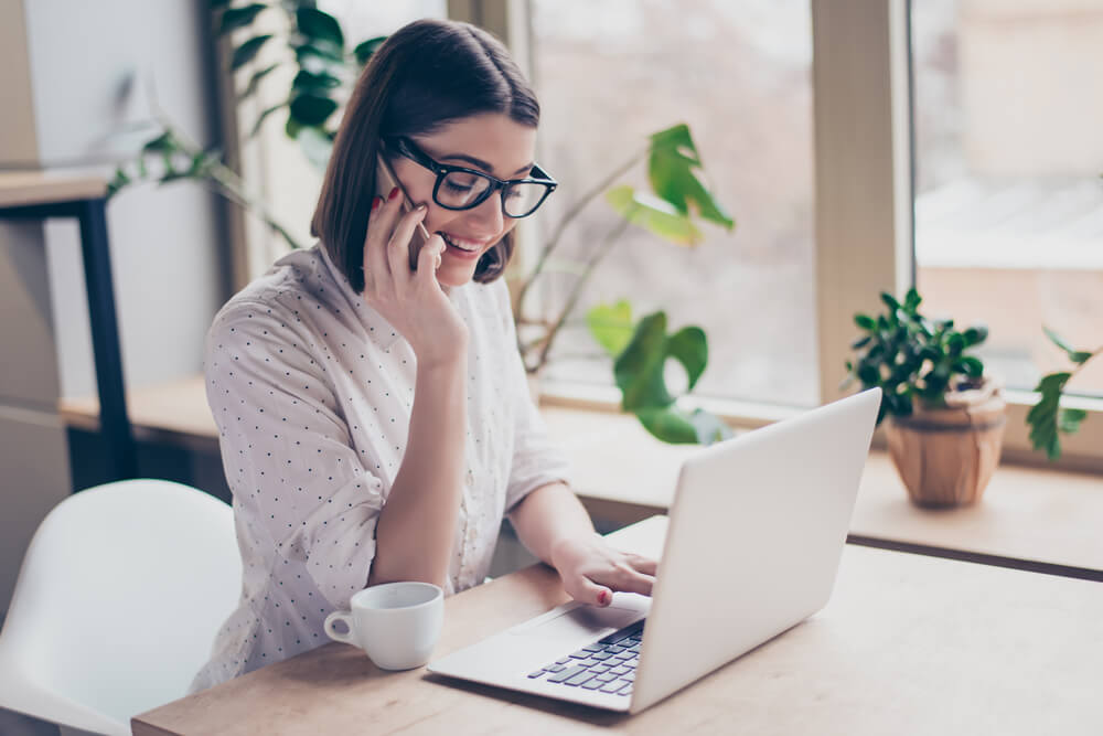 Woman talking on phone and applying for payday loans online