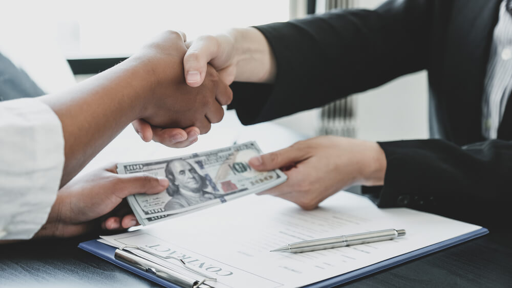 client and representative handshaking and payday loan cash in hand