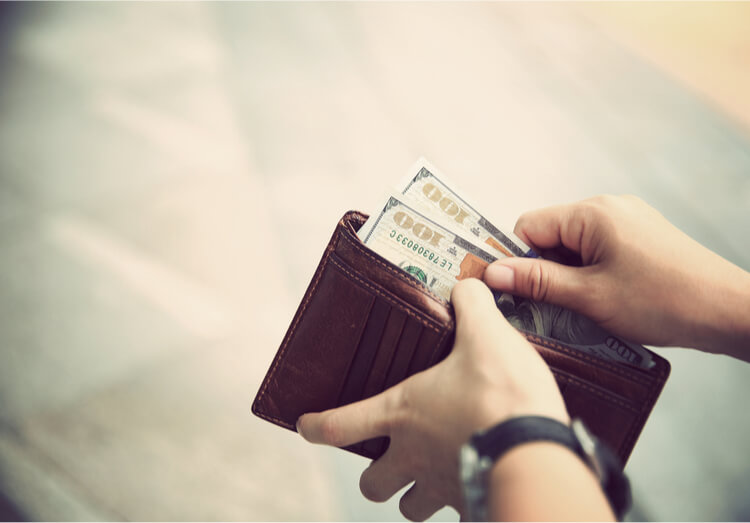 Person placing title pawn cash into wallet