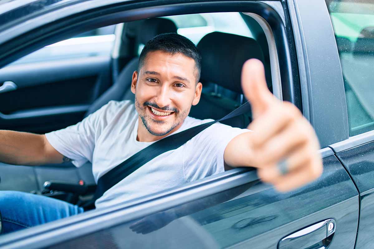 Man happy in his car giving thumbs up from getting title loan