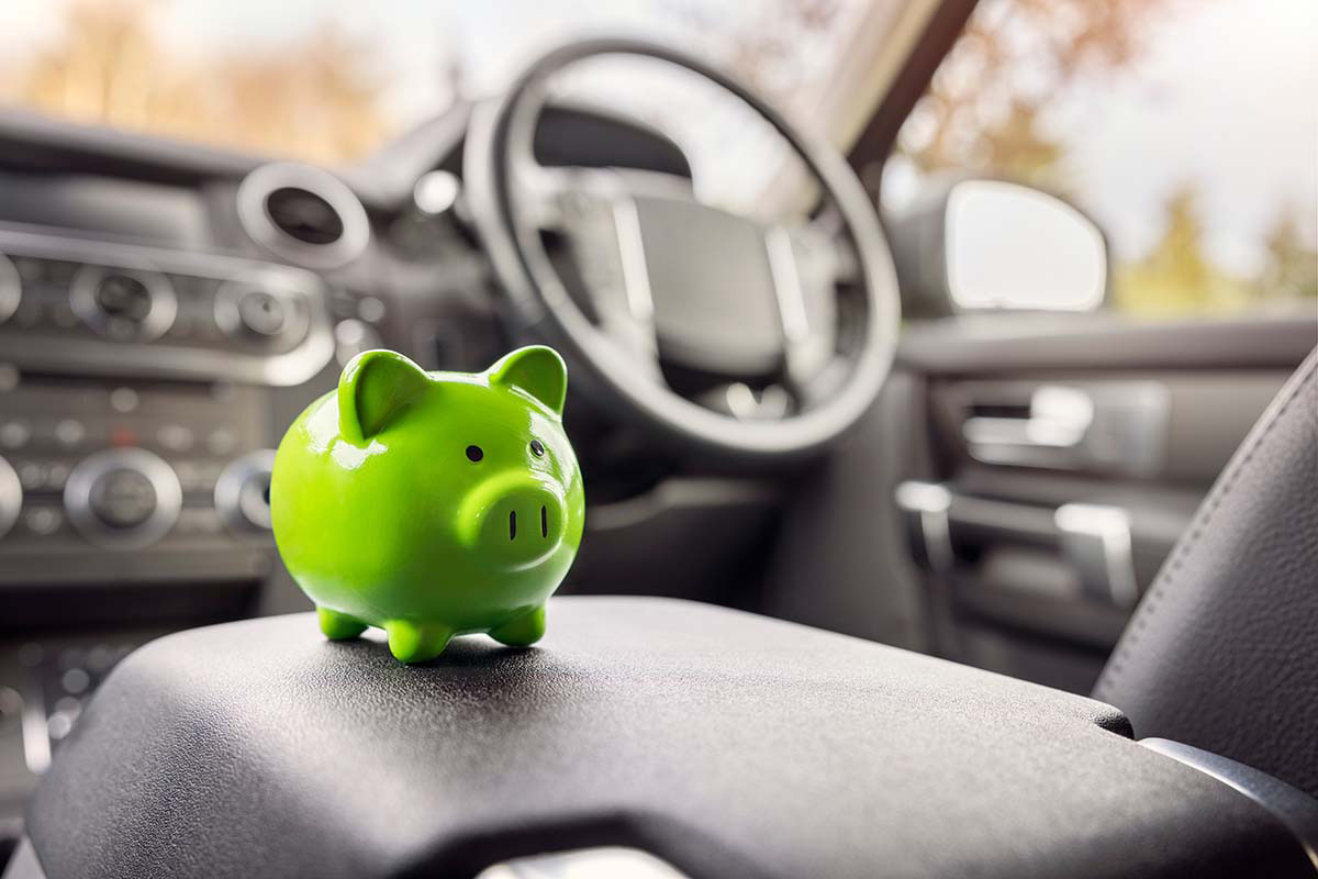 green piggy bank sitting on center console of car for getting money from auto title loans in Texas