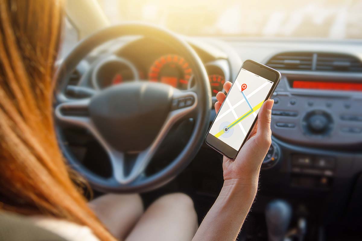 While driving to your title loan, a girl can be seen inside a car, using a map to locate a specific place. She is holding a phone, presumably for navigation purposes.