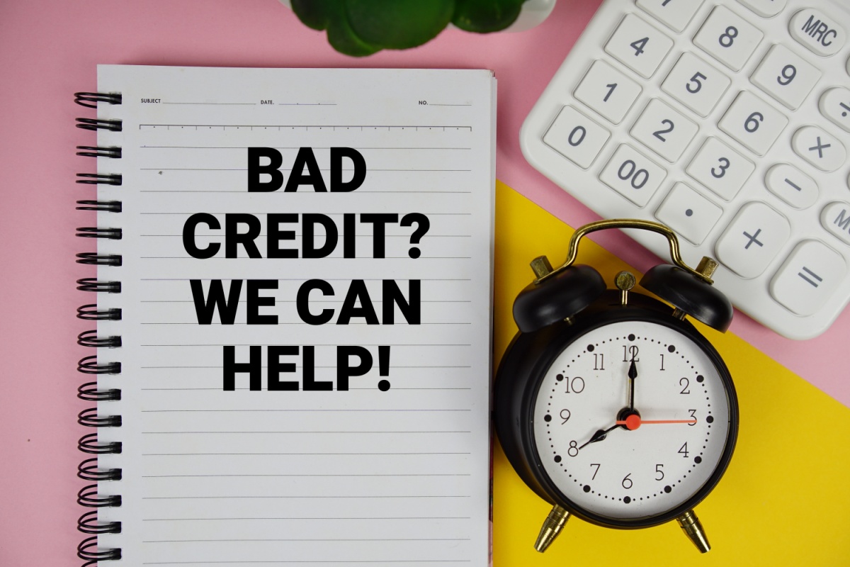 clock, calculator, and a notebook that says "bad credit? we can help!"