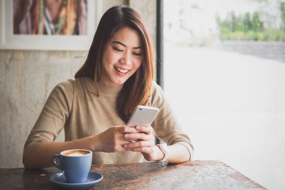 woman on phone looking up registration loan process online