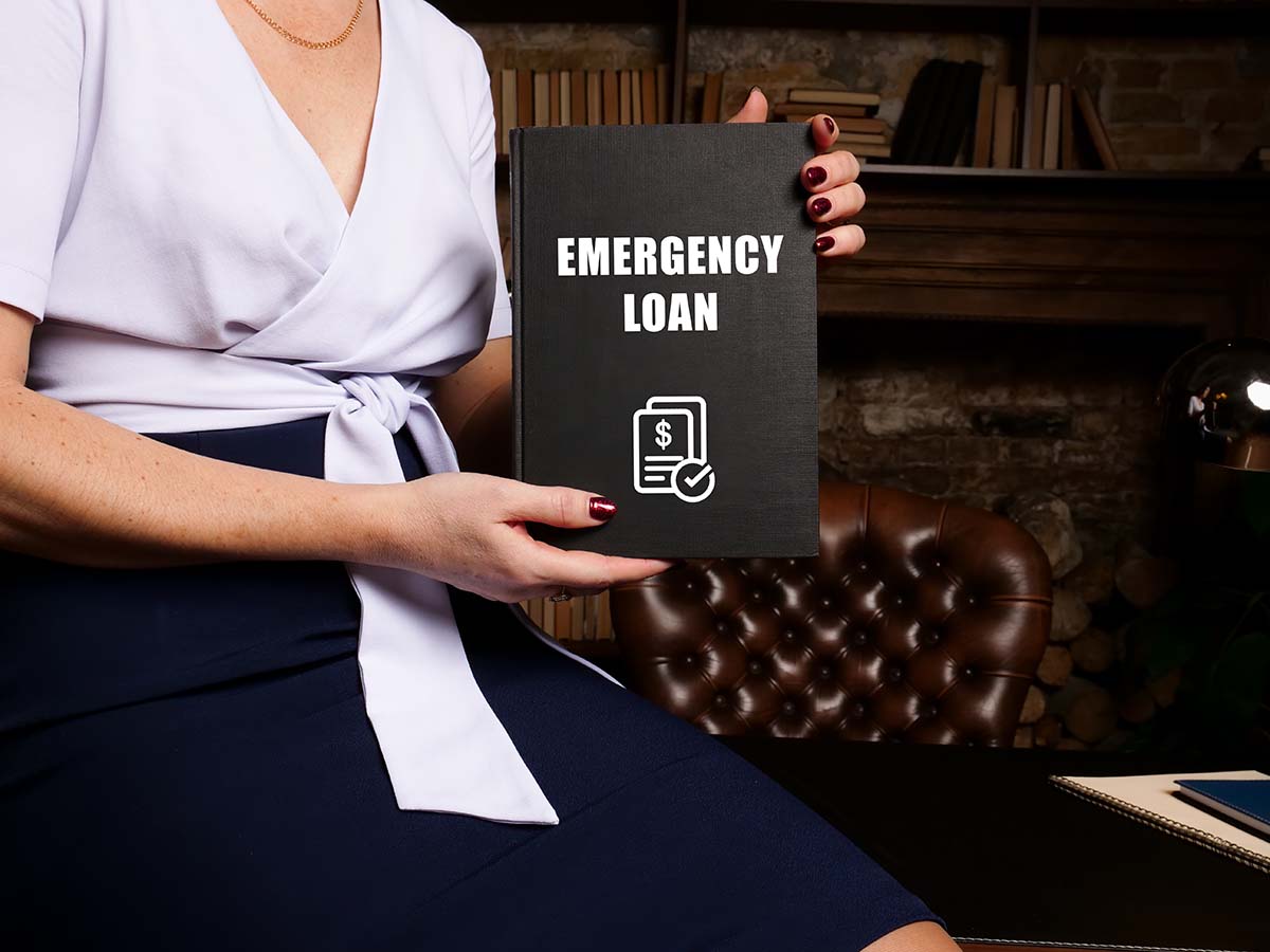 woman sitting in office library holding emergency loans book in her hands