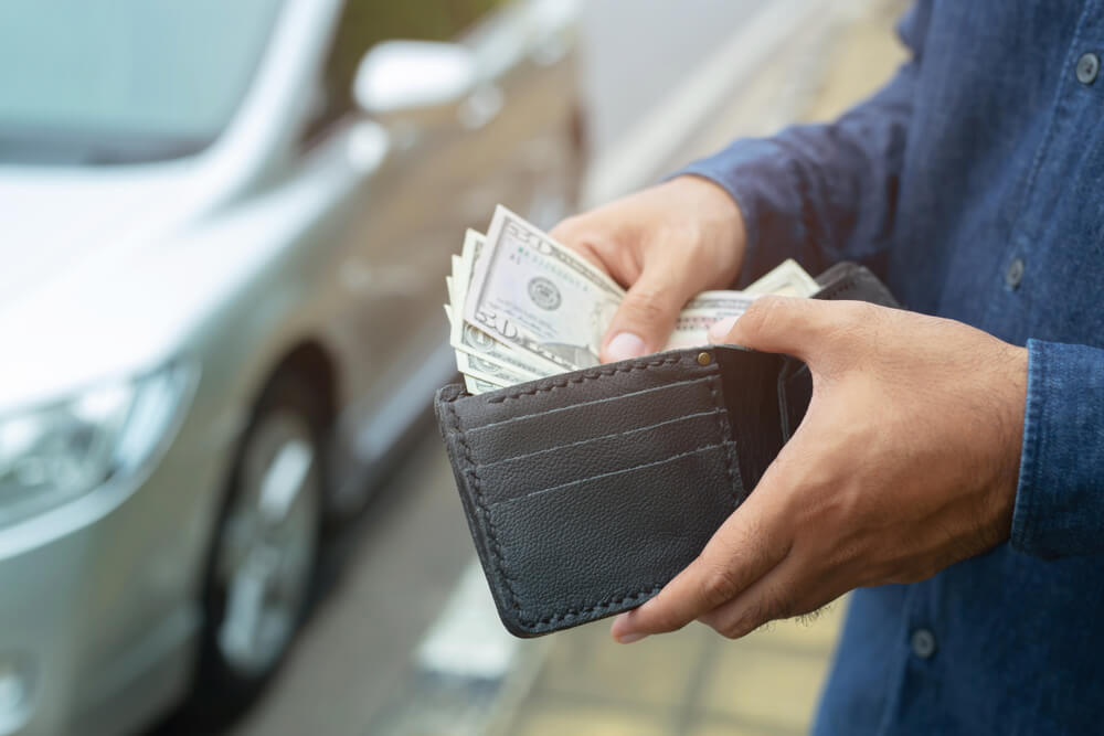 man putting title pawn cash in wallet