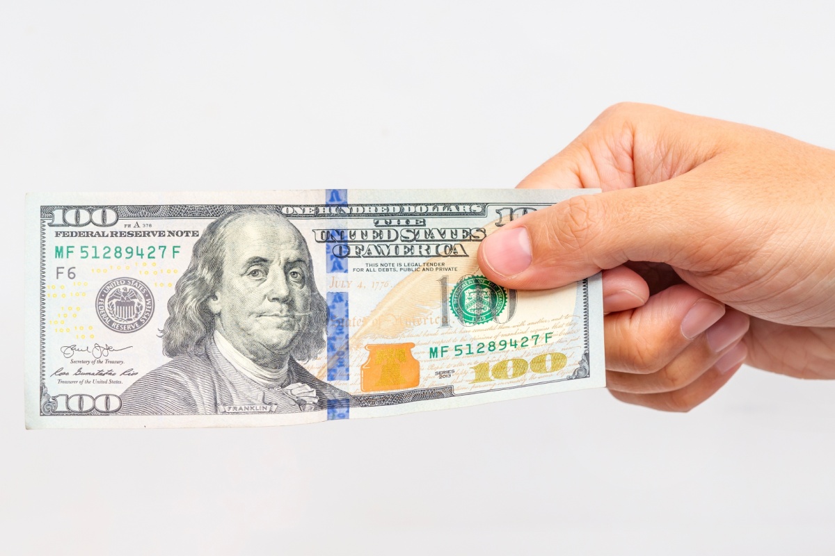 hand holds $100 bill from title loan