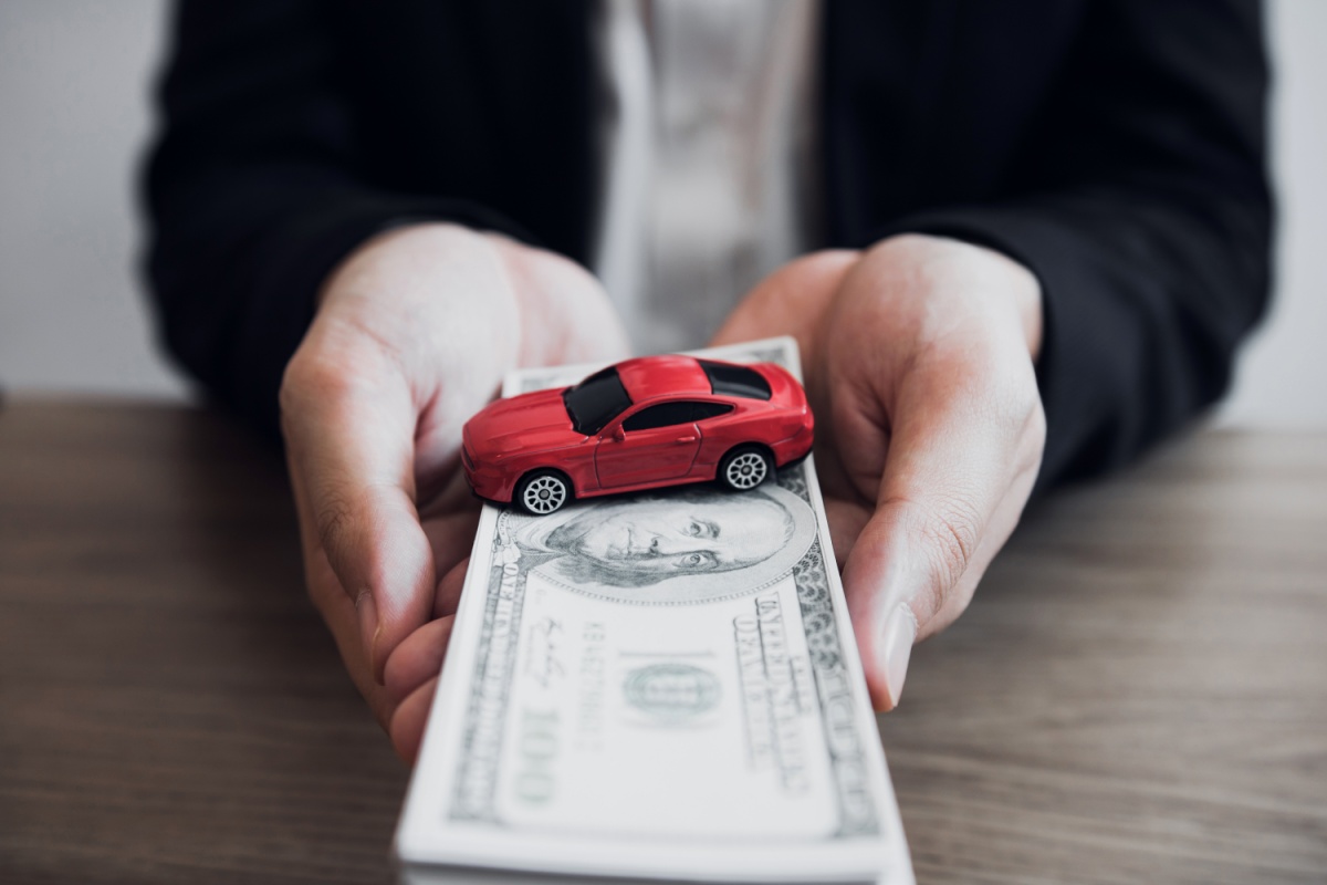 holding cash from Arizona title loan and toy car