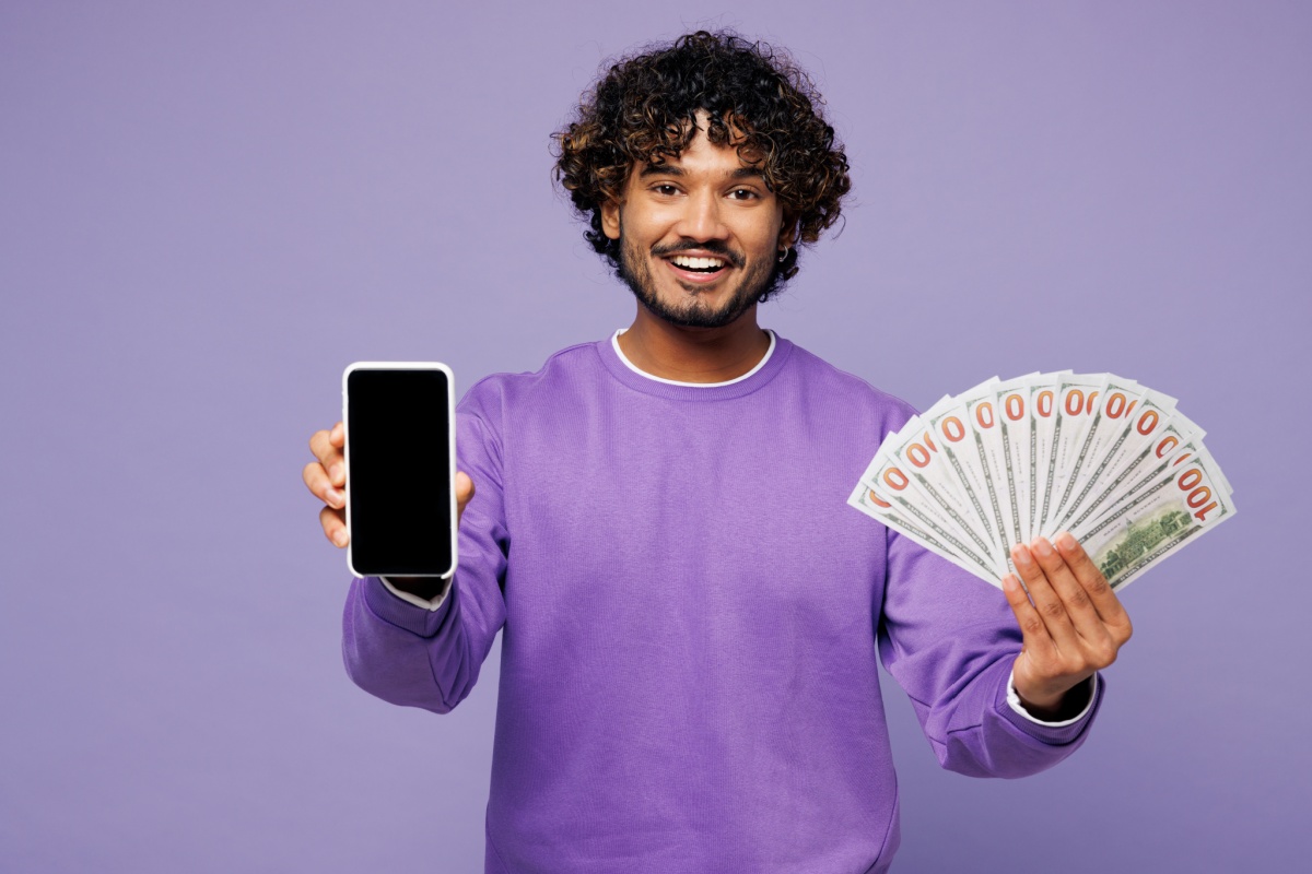 Man holding title loan cash and phone for online form
