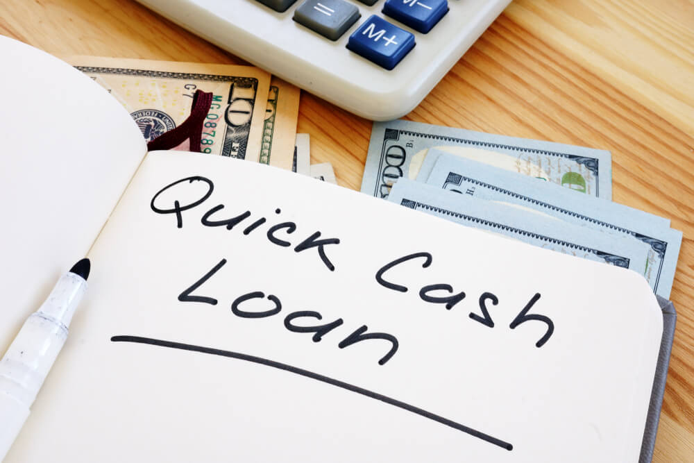 Calculator, title loan cash and notepad with Quick cash loan for bad credit written on it