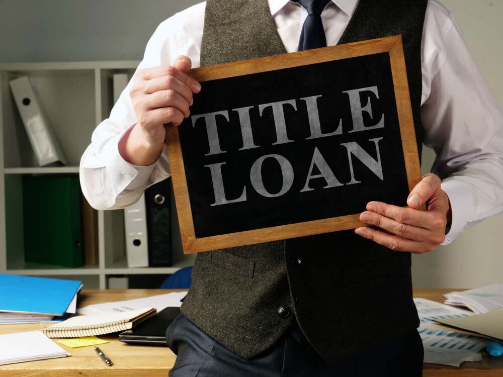 man holding up online title loans sign