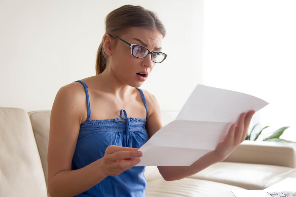 woman opening mail and is in shock from student loan debt