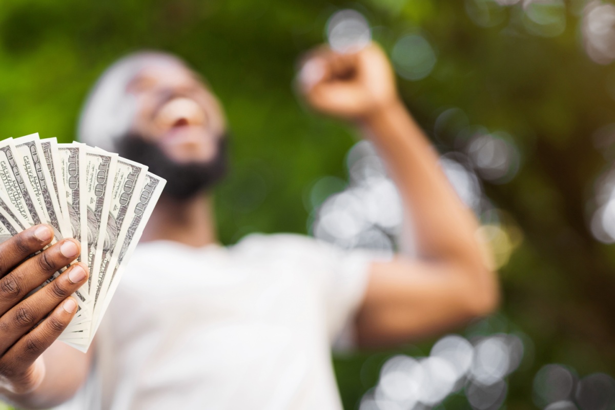 man holding cash from personal loans for emergencies