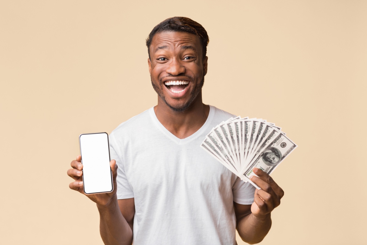 man holds cash after getting approved for an online loan