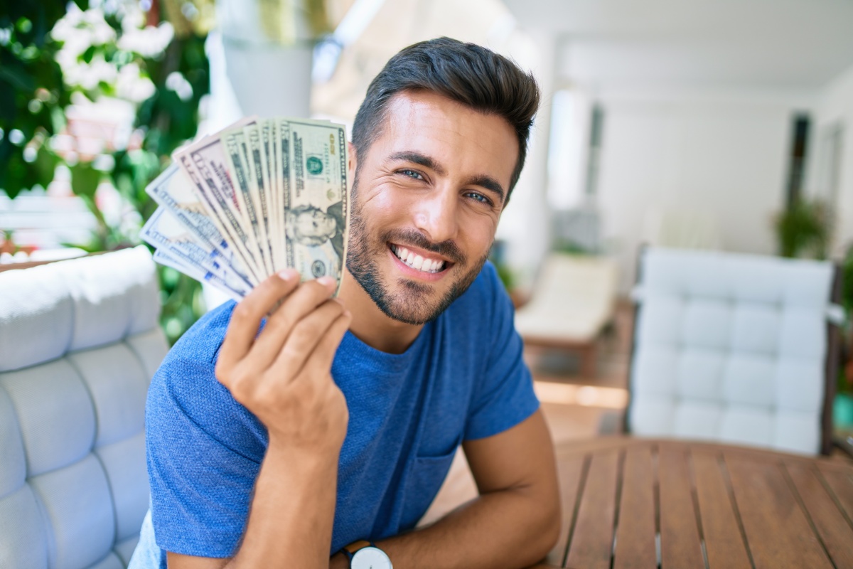 man holds online payday loan cash