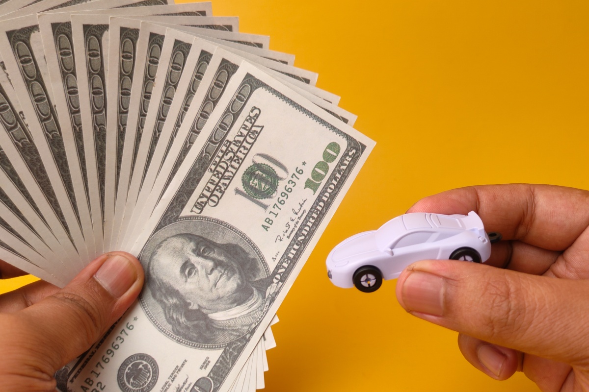 man holds toy car and Mississippi title loan cash
