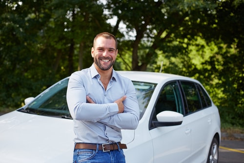 Handsome_man_standing_in_front_of_car...