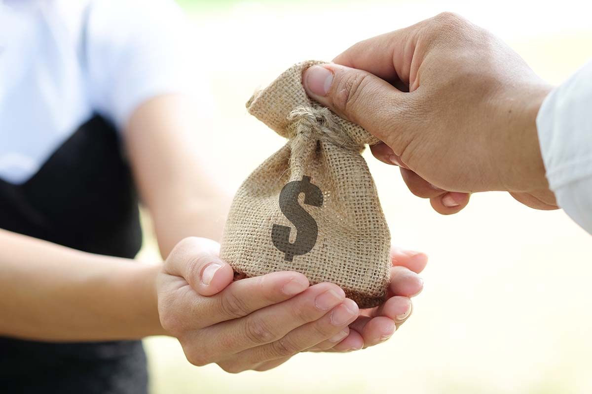 A bag of title loan money being exchanged between two people.