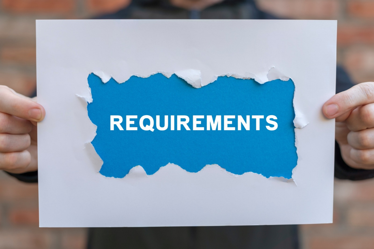 person holding ripped requirements sign