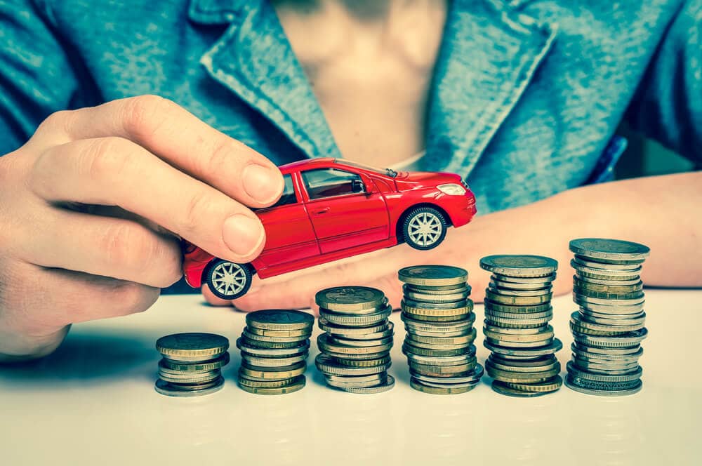 person holding toy car and coins