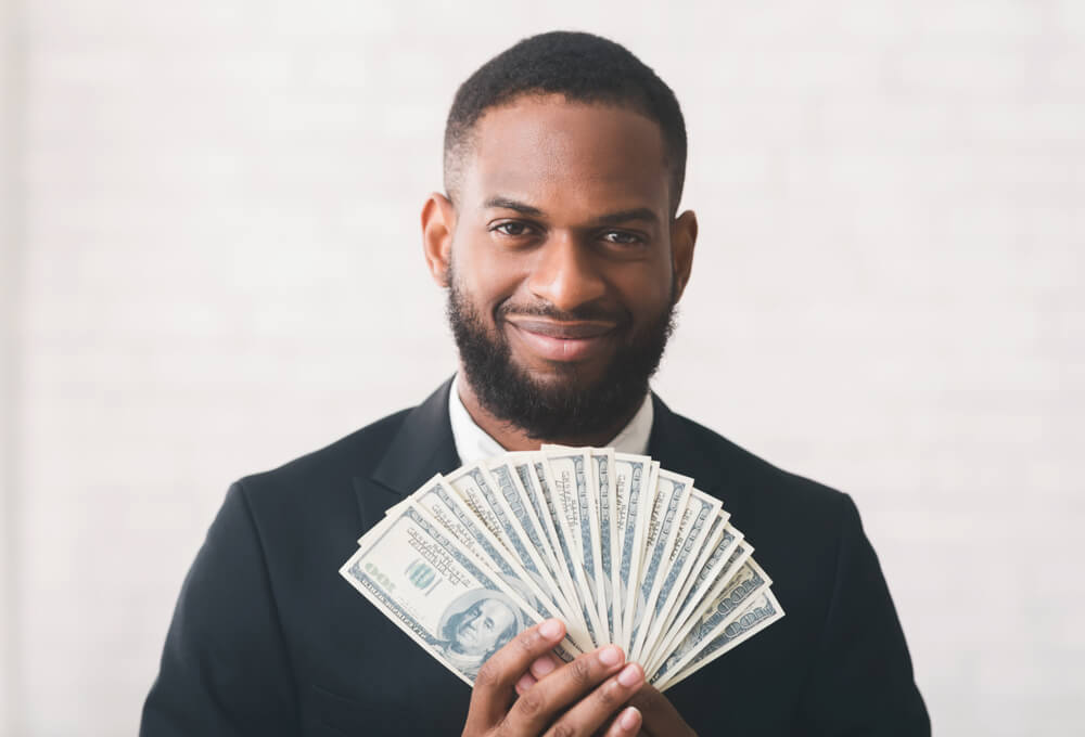 man holds cash from bad credit installment loan