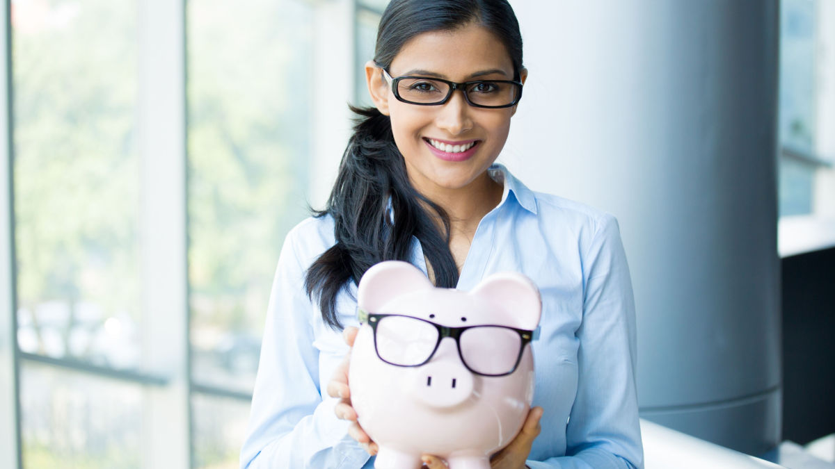 A woman with glass holds up a piggy bank after she receives a payday loan.