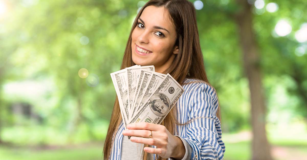 woman holding up title loan cash from easy loans for immigrants in Arizona