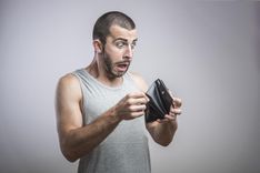 man struggling and looking at empty wallet thinking what to do if you are broke