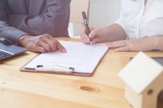 Client signing payday loan paperwork next to representative