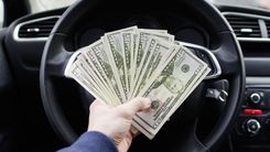 hand holding Carson City title loan cash in car