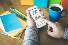 man looking at his phone to improve credit score fast
