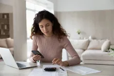 woman sitting in her living room applying for online title loan from her countertop
