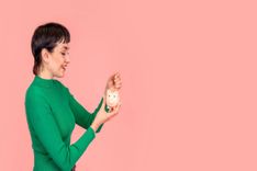 woman putting coins in a jar for financial emergency