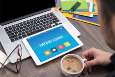 man sitting at his desk looking for payday loans in Tennessee on device