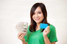 happy woman holding title loan cash and card from Nevada Title and Payday Loans, Inc.