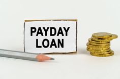 payday loan sign pencil and coins on top of desk for financial lifeline 